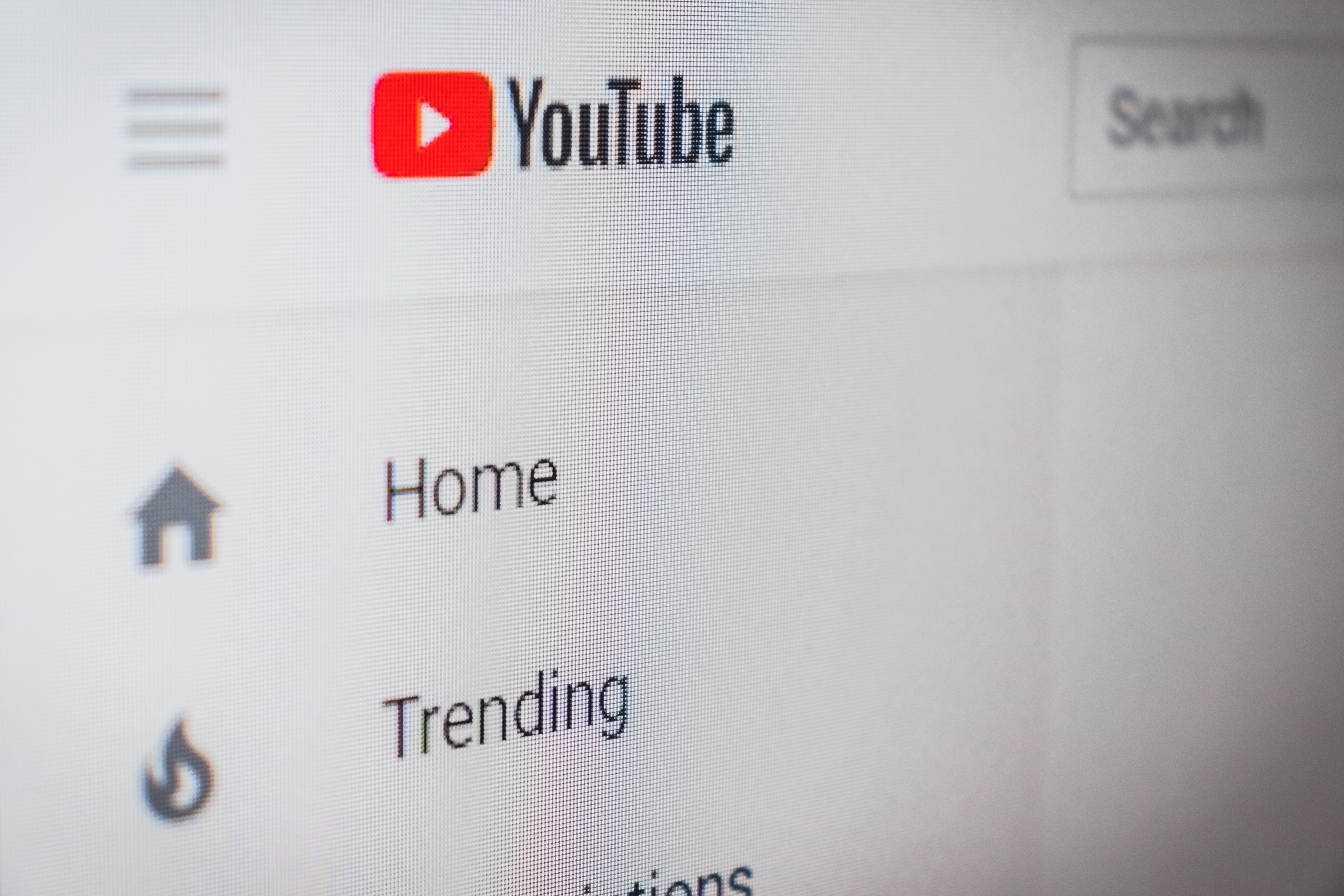 Image of a YouTube channel with its logo on top and Home and Trending buttons below it.